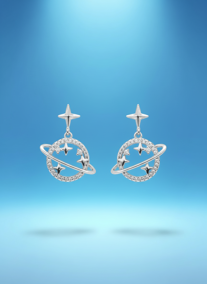 Sterling silver Saturn planet earrings styled with celestial Y2K aesthetic and layered jewelry look.
